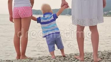 妈妈和姐姐手牵小男孩在沙滩自然户外，信任家庭观念.. 家人手牵手